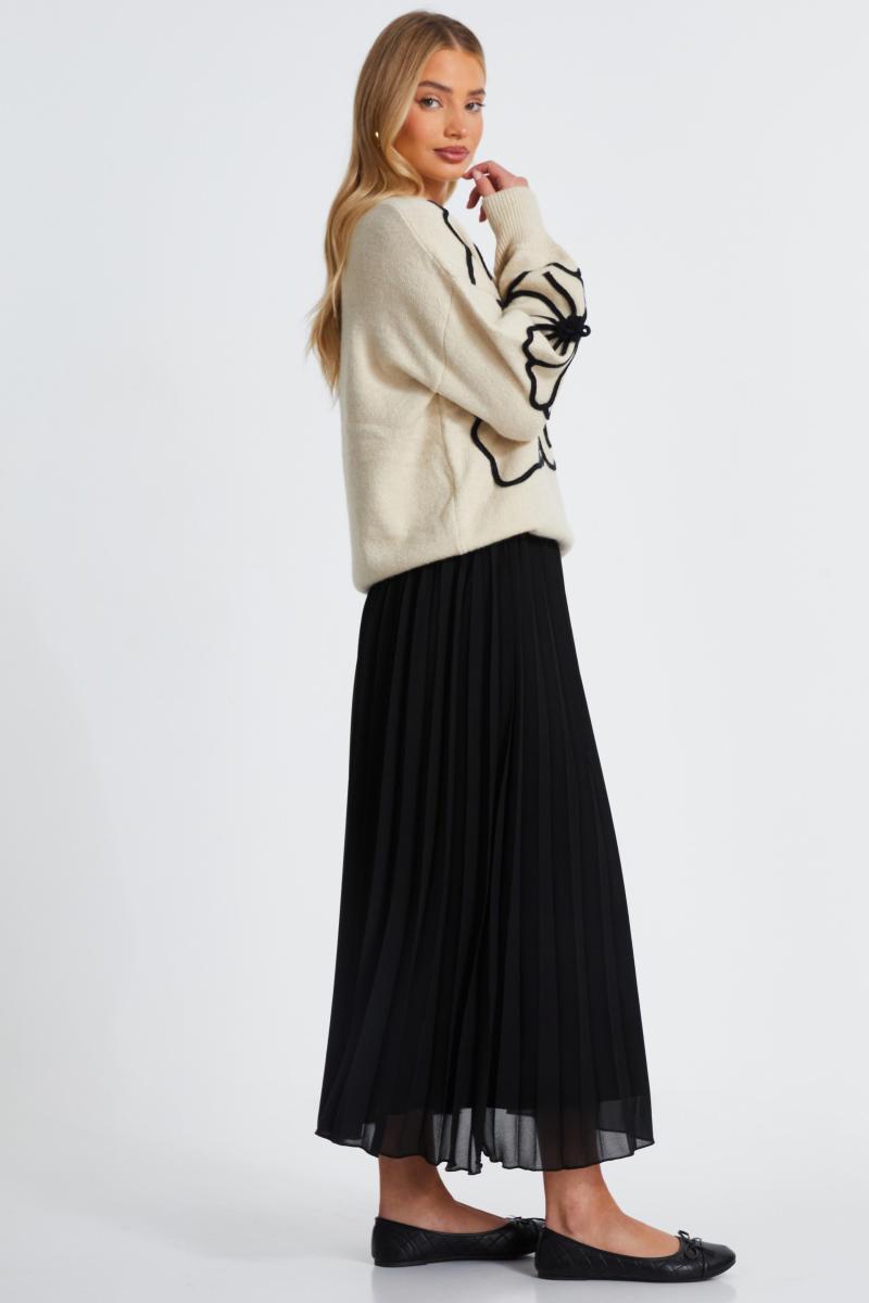 Біля білого в’язаного квіткового джемпера